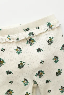 Białe legginsy niemowlęce w kwiatuszki z materiału pointelle