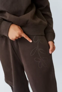 Brązowe spodnie dresowe dziewczęce baggy z wypukłym nadrukiem.