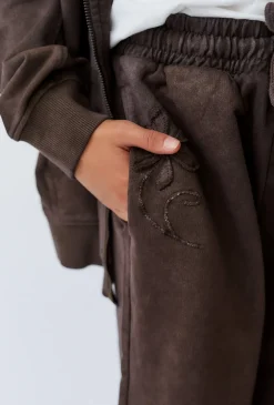 Brązowe spodnie dresowe dziewczęce baggy z wypukłym nadrukiem.