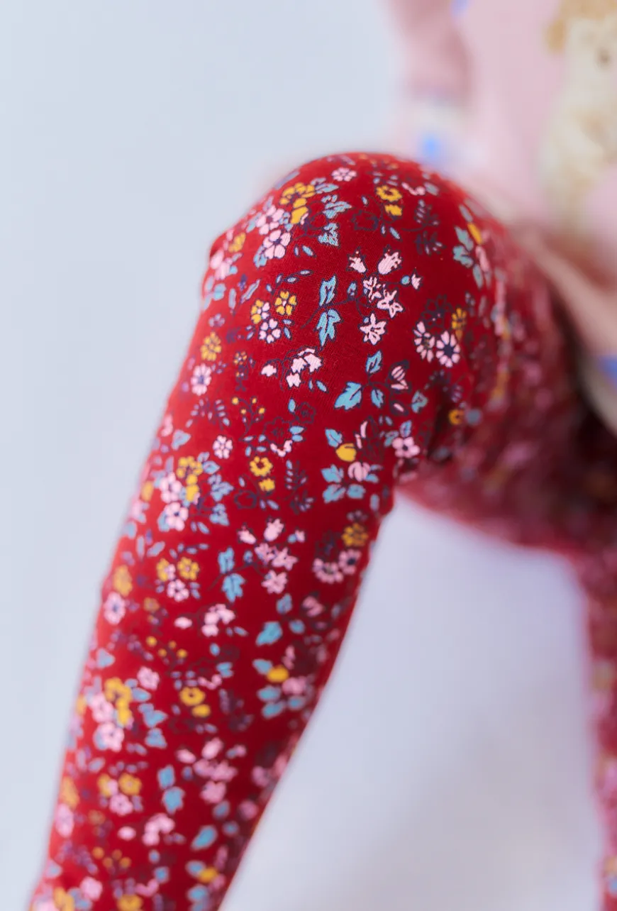 Czerwone legginsy dziewczęce z kwiatowym nadrukiem.