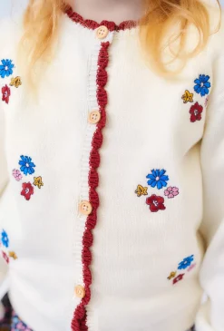 Dziewczęcy sweter ecru z kwiatowymi haftami.