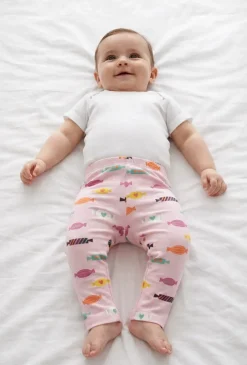 Różowe legginsy dziewczęce z nadrukiem cukierków.